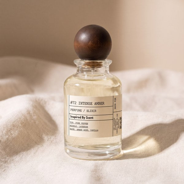 A single clear perfume bottle on cream linen in hard side light